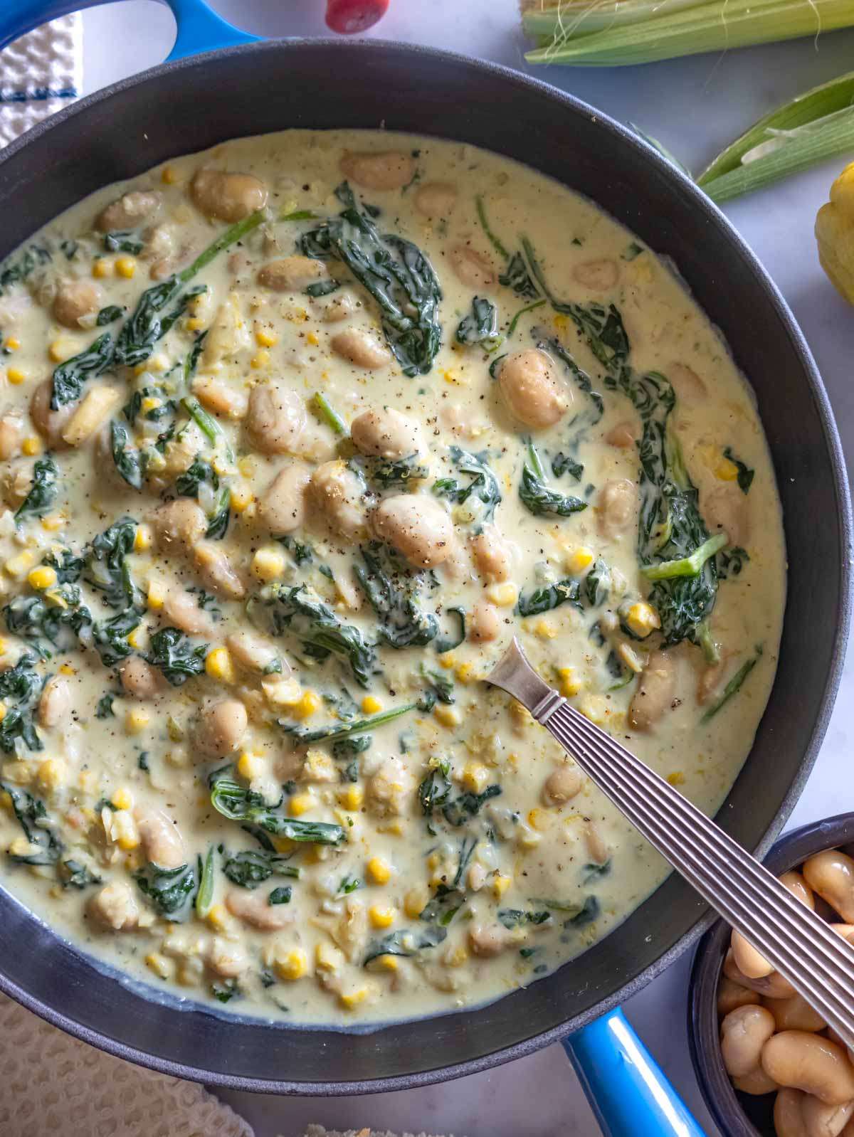 Creamy butter beans in Florentine sauce served in a skillet topped with lemon and parmesan.