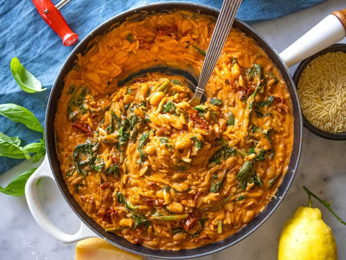 Creamy marry me orzo in a skillet with a spoon.