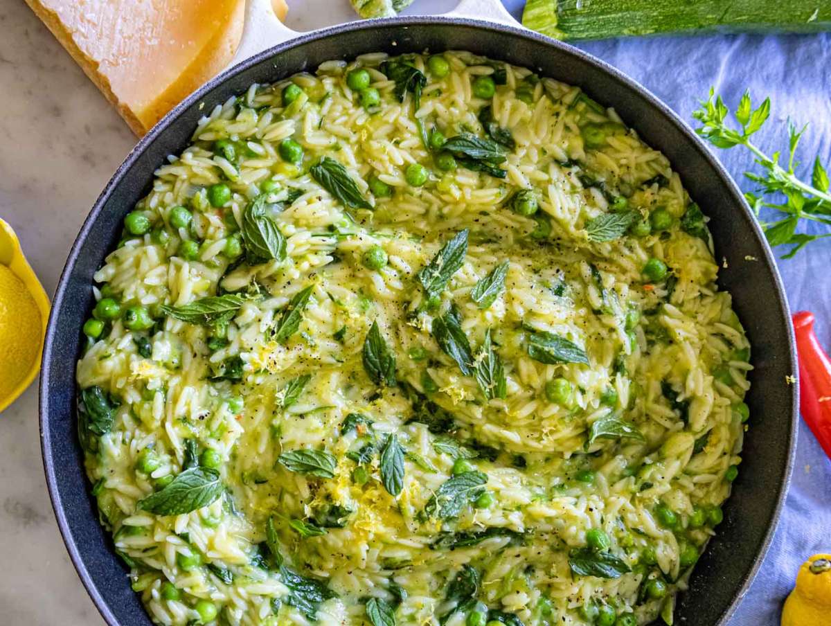 Finished lemon orzo with zucchini served in bowls, topped with mint and extra cheese.
