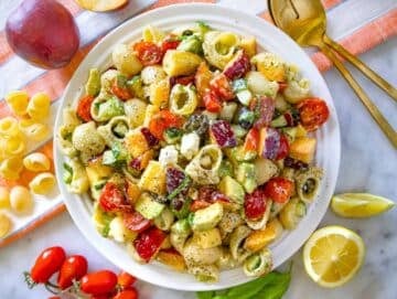 Fully mixed summer pasta salad on a platter, creamy and colorful, ready to enjoy.