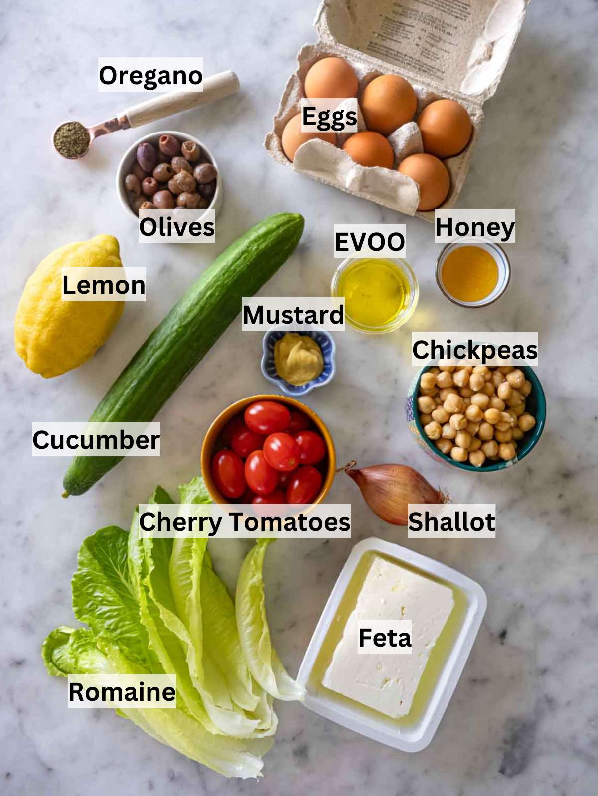 Ingredients for Mediterranean chopped salad including lettuce, chickpeas, eggs, and dressing in small bowls.