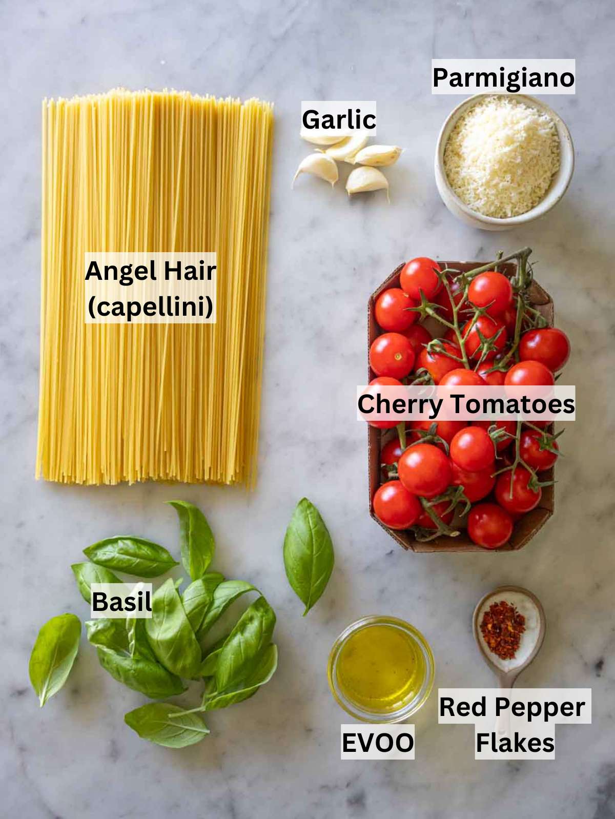 Ingredients for angel hair pasta with fresh tomatoes, garlic, basil, olive oil, and parmesan.