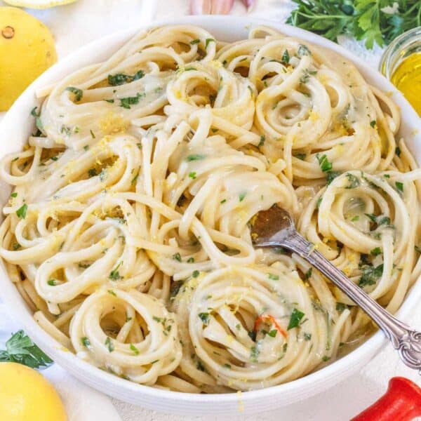 Lemon pasta without cream served in a white bowl, styled with fresh lemons, parsley, and a drizzle of olive oil—light and fresh Italian dinner idea.