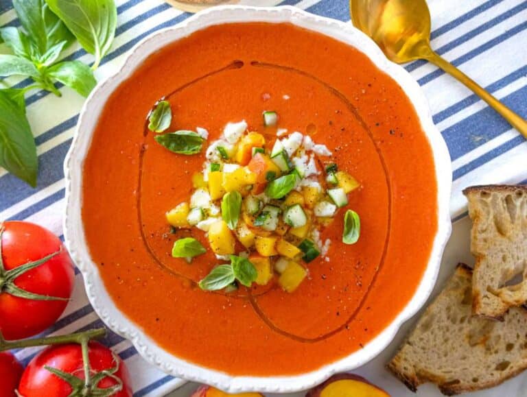 Served peach gazpacho in a bowl with toppings, ready to enjoy.