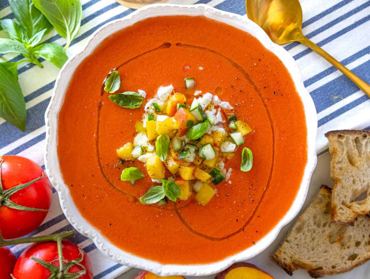 Served peach gazpacho in a bowl with toppings, ready to enjoy.