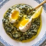 Spanakorizo in a white bowl healthy Greek spinach and rice dish with poached egg.