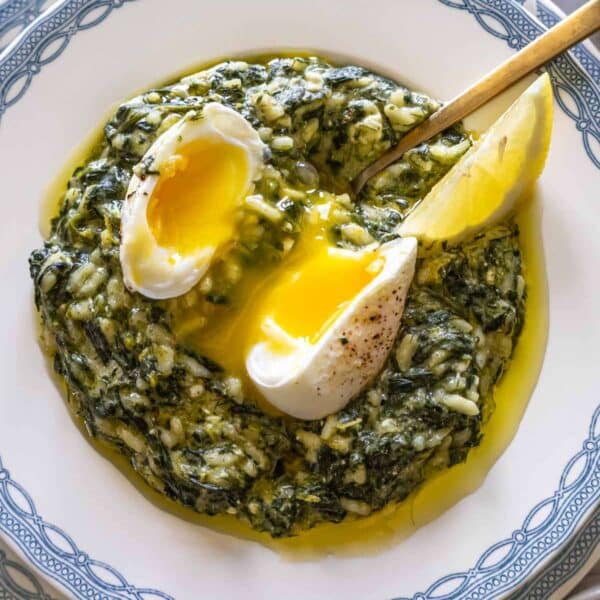 Spanakorizo in a white bowl healthy Greek spinach and rice dish with poached egg.