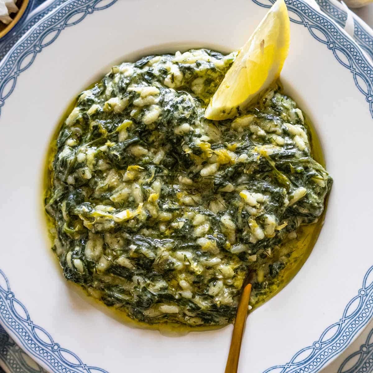 Spanakorizo with lemon on a Greek plate.