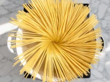 Step 1 Spaghetti boiling in salted water on marble counter top.