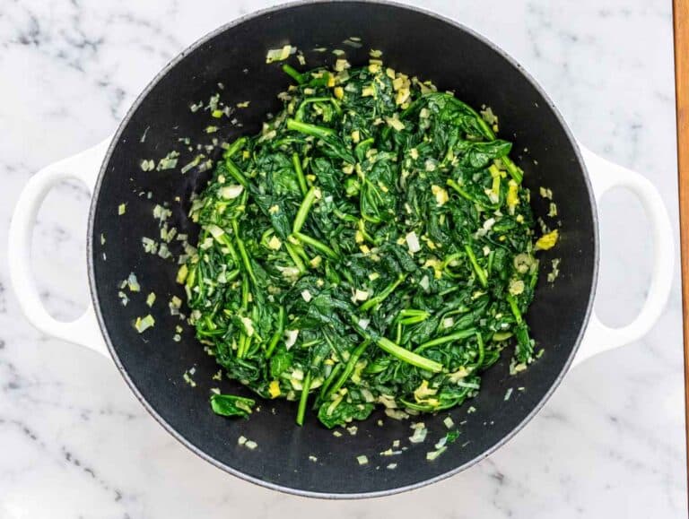 Step 2 Fresh spinach wilting with softened aromatics until tender and deep green.