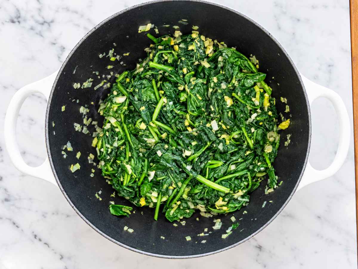 Step 2 Fresh spinach wilting with softened aromatics until tender and deep green.