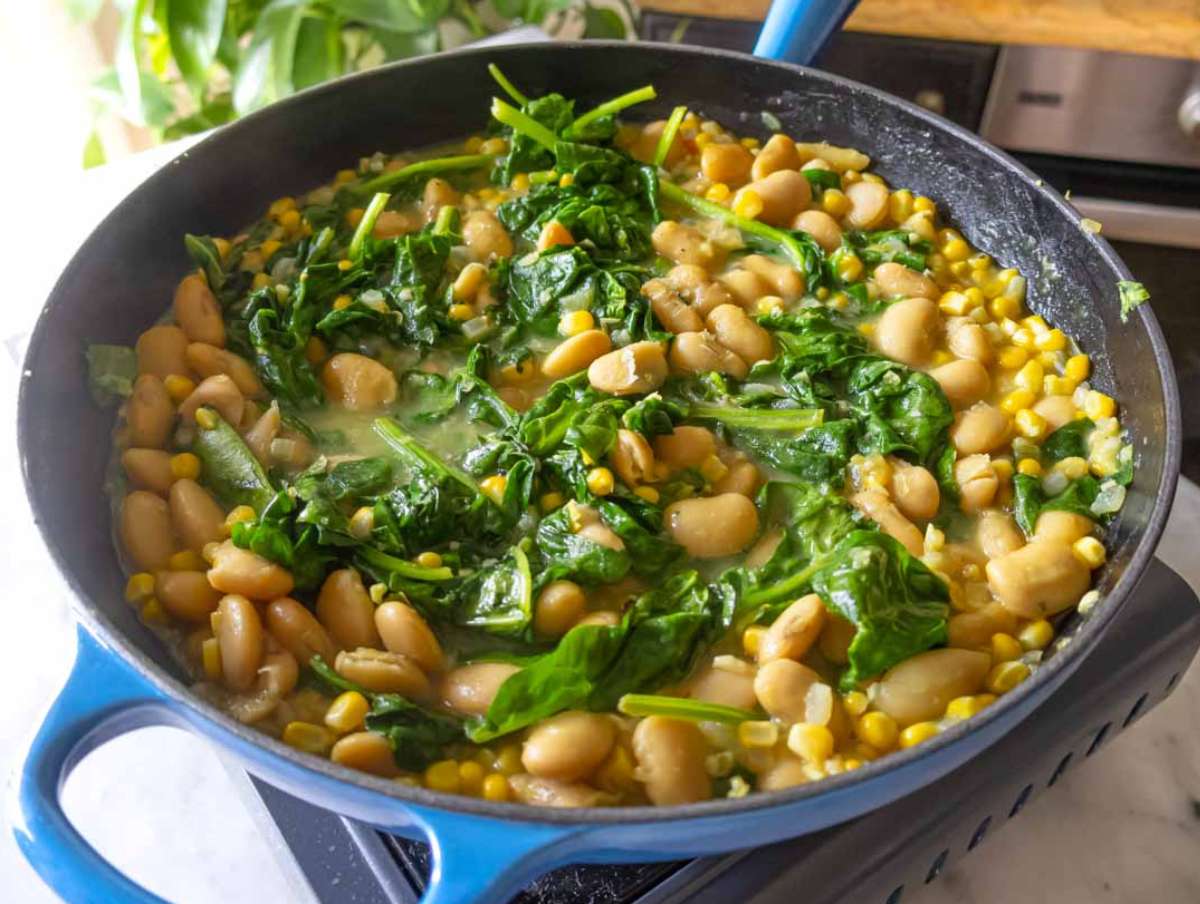 Step 3 Fresh spinach wilting gently into the creamy butter bean sauce.
