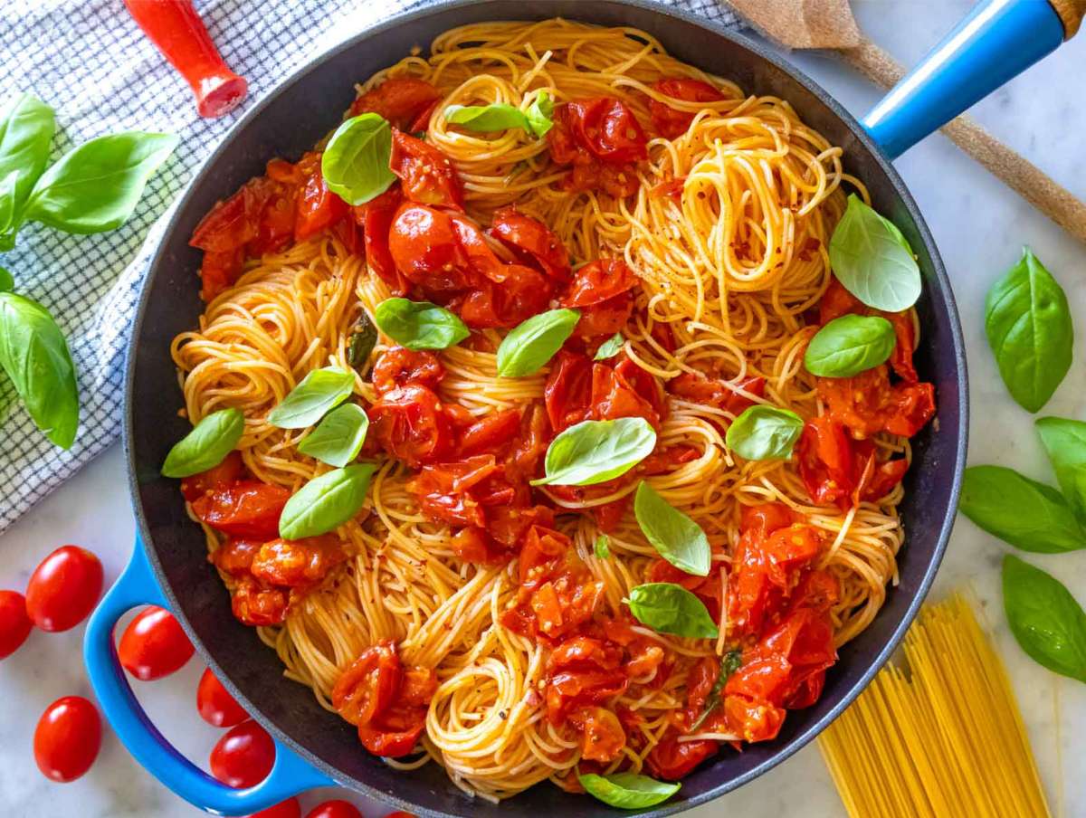 Step 5 Grated parmesan melting into angel hair pasta with tomatoes, garnished with basil and olive oil.