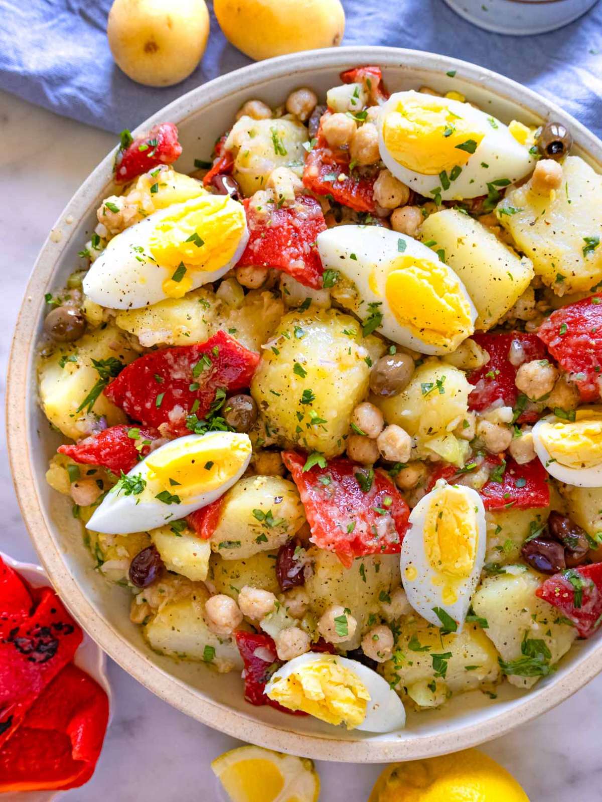 Top-down view of Mediterranean potato salad with red peppers, potatoes, and oregano vinaigrette, ready to serve.