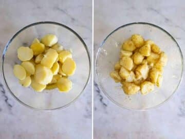 Warm potato chunks being gently mixed with oregano vinaigrette in a large mixing bowl.