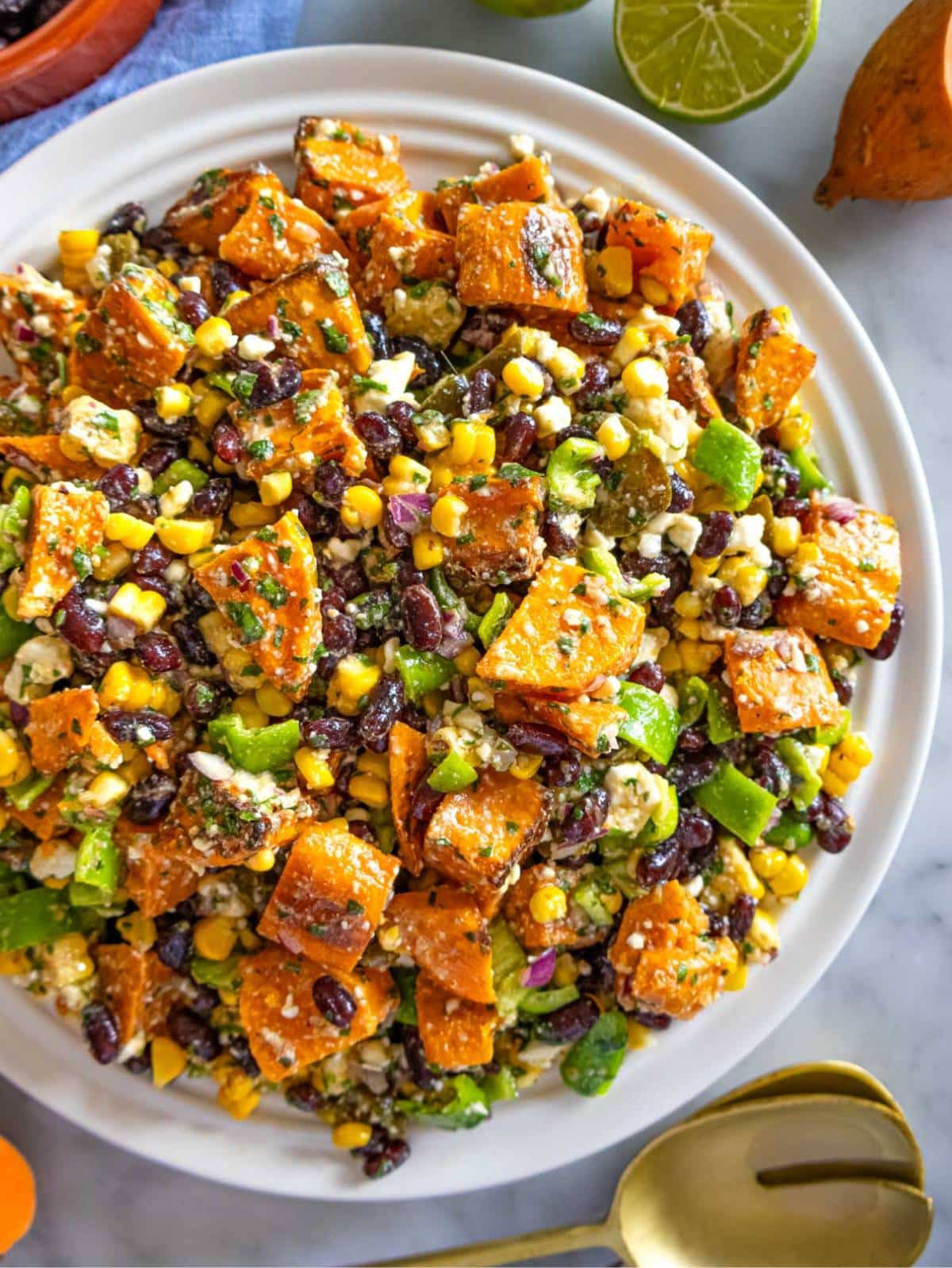 Black bean corn salad served in a bowl with roasted sweet potatoes and feta.