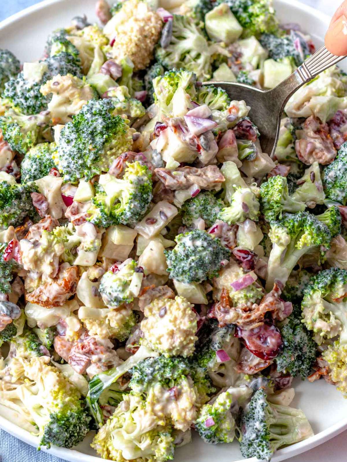 Close up Greek yogurt broccoli salad with cranberries almonds and creamy dressing.
