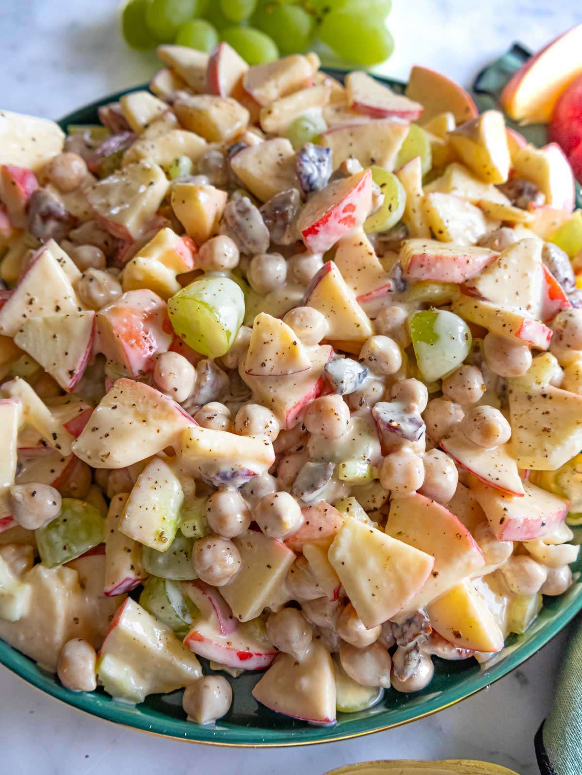 Close up of creamy apple chickpea salad with grapes pecans and cranberries.