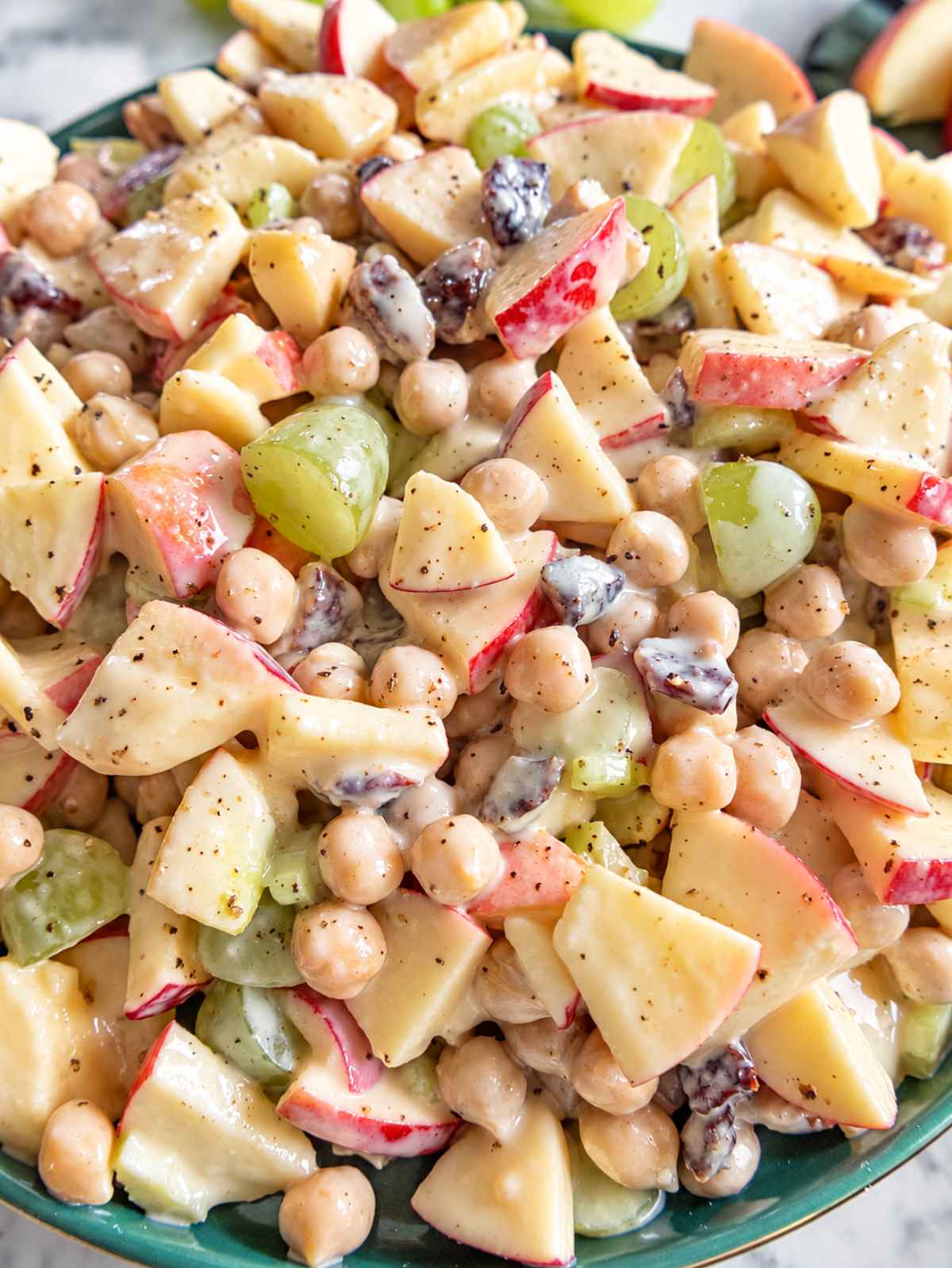 Close-up of glossy apple chickpea salad coated in creamy yogurt dressing.