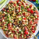 Colorful dense bean salad with feta, parsley, vegetables, and lemon vinaigrette.