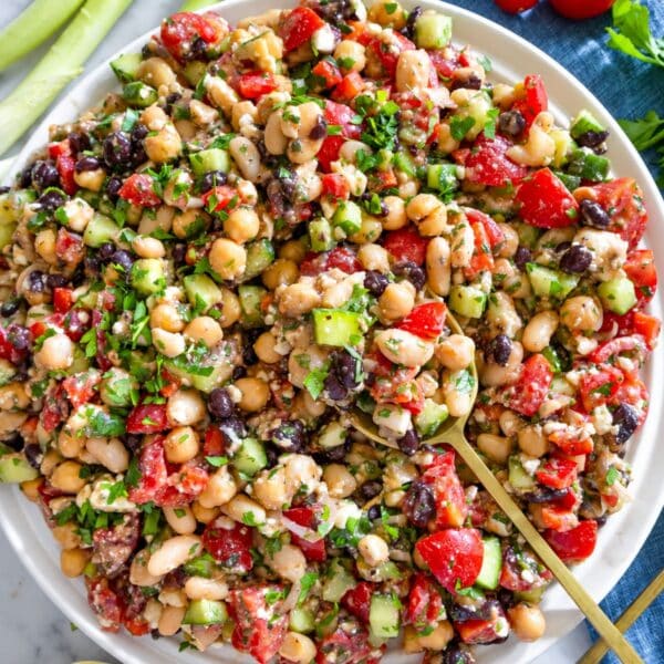 Colorful dense bean salad with feta, parsley, vegetables, and lemon vinaigrette.