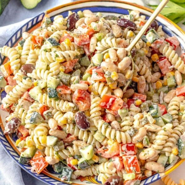 Creamy Greek yogurt pasta salad with beans and vegetables in a serving bowl.