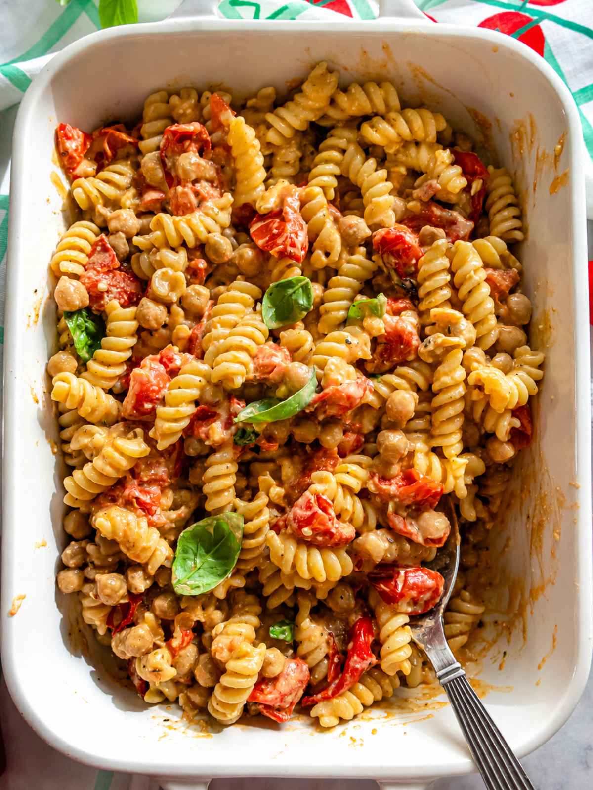 Creamy feta pasta in a casserole with a silver spoon.