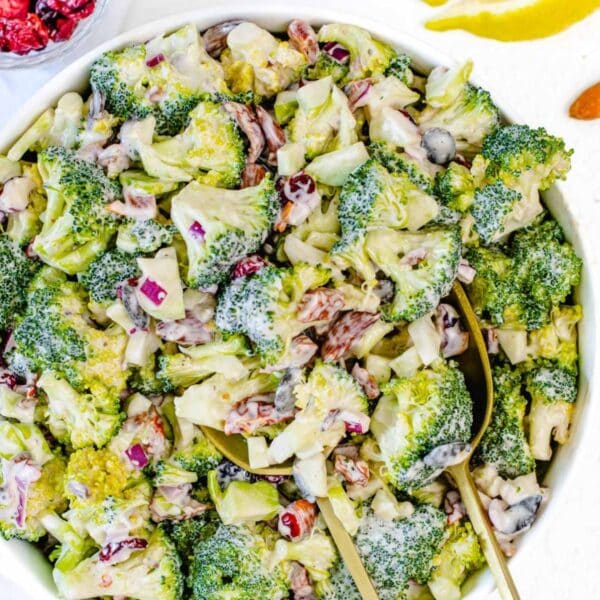 Fresh Mediterranean broccoli salad with yogurt dressing cranberries almonds and seeds on a table.