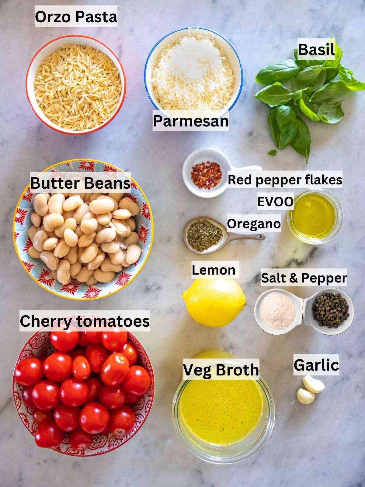 Fresh ingredients for cherry tomato orzo including tomatoes beans orzo basil and parmesan.