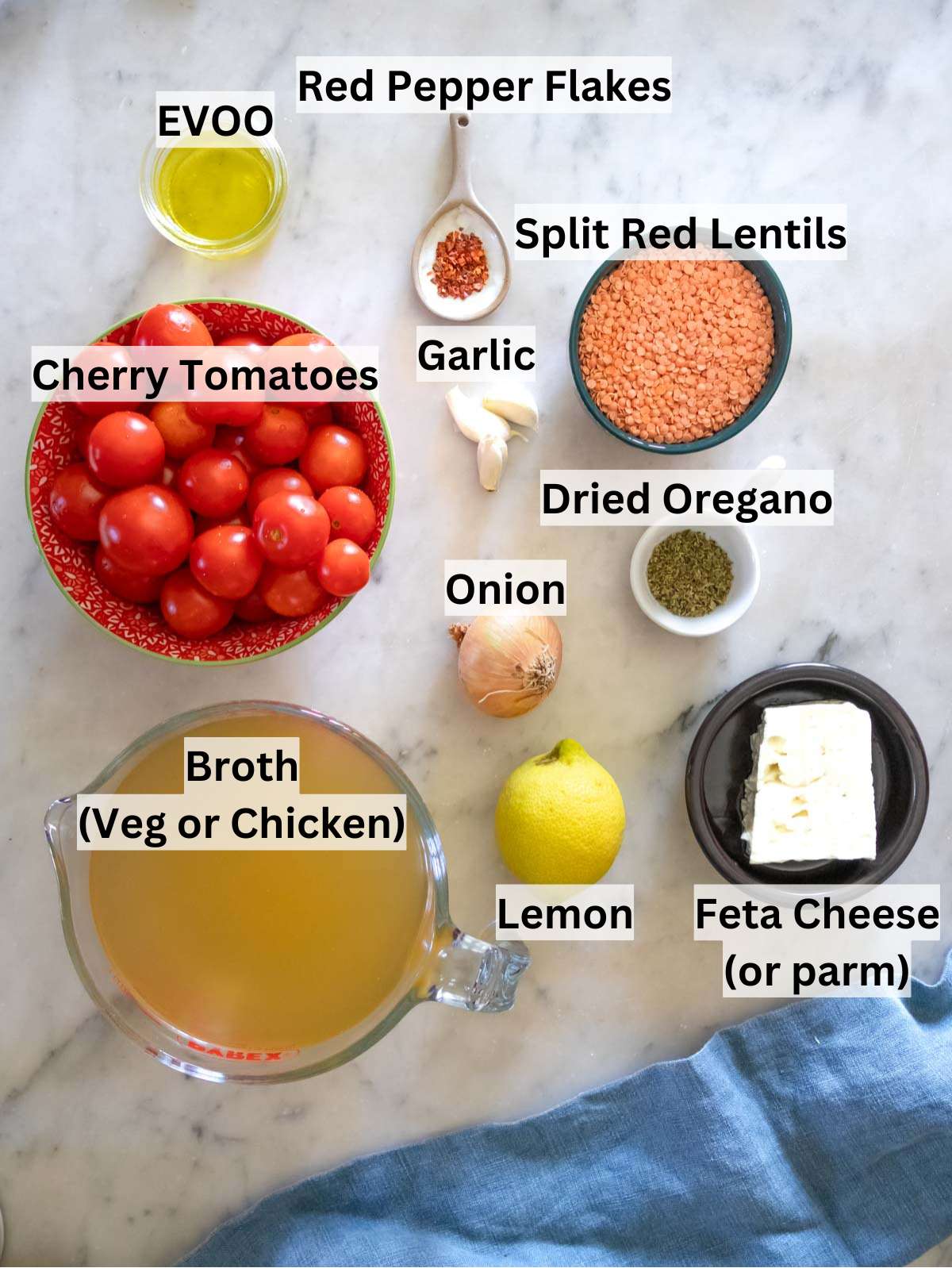 Fresh ingredients for lentil tomato soup including cherry tomatoes garlic onion and lemon.