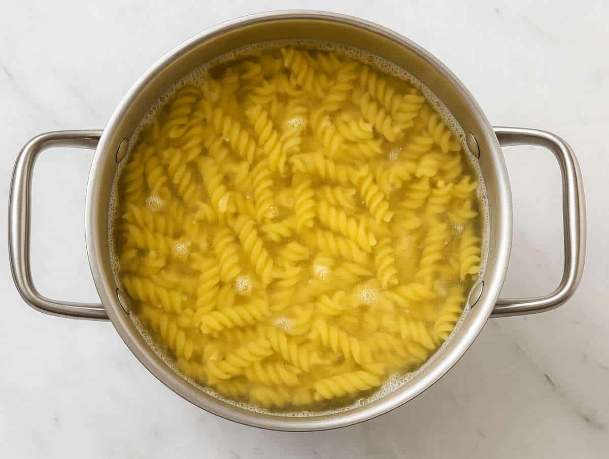 Fusilli pasta boiling in salted water in large pot.