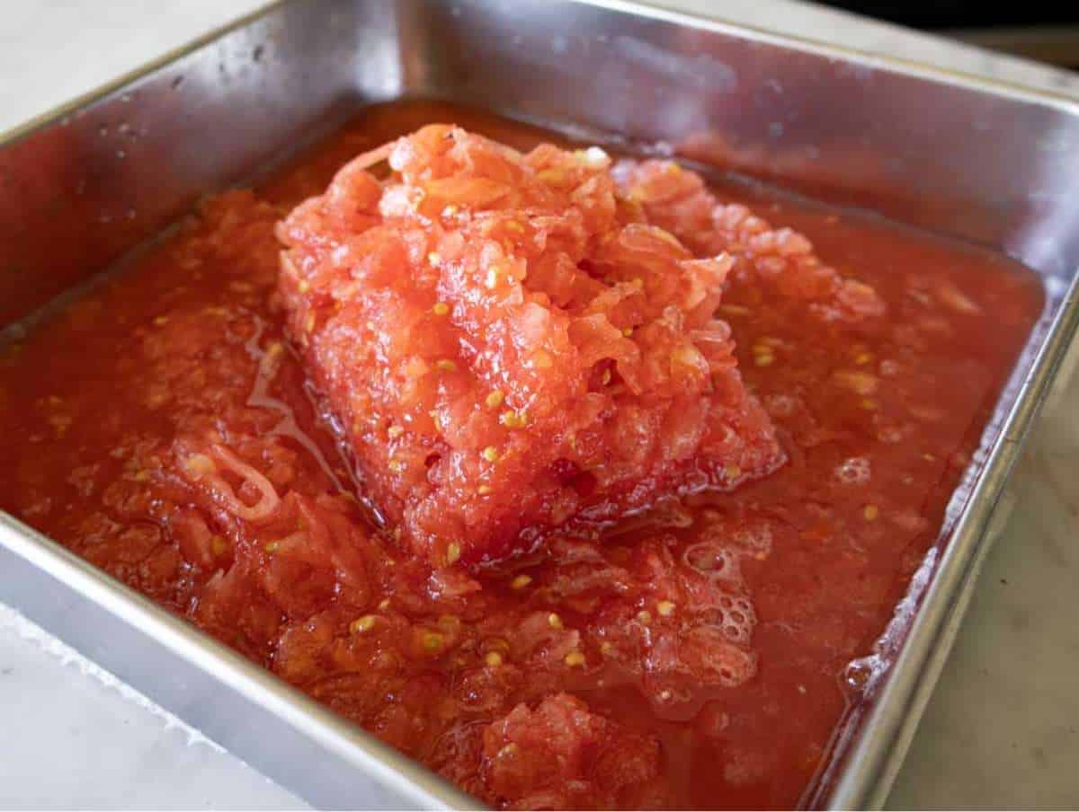 Grated fresh tomatoes in a bowl for Greek scrambled eggs recipe