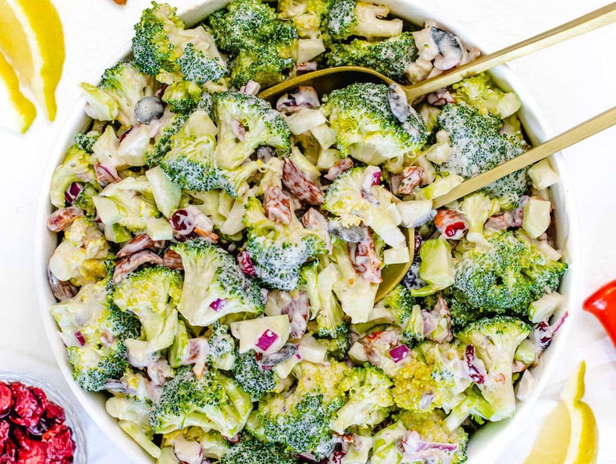 Healthy broccoli salad with Greek yogurt dressing served in a white bowl.