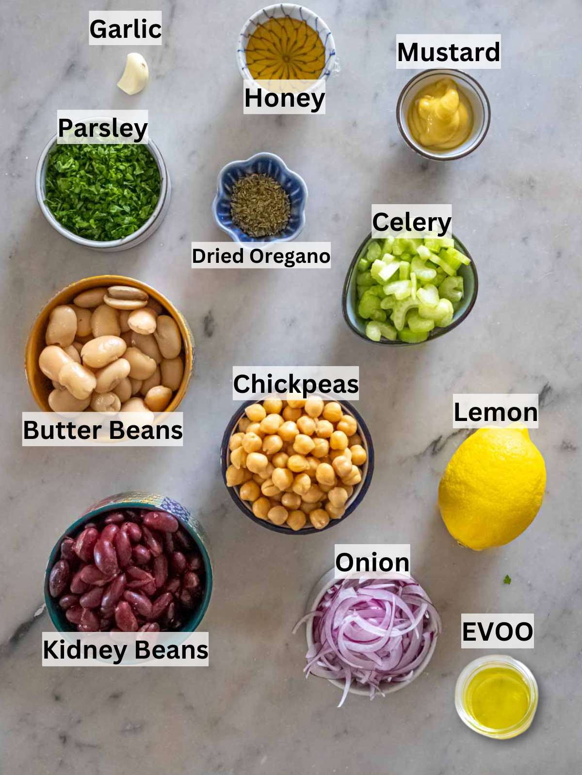 Ingredients for 3 bean salad recipe with beans onion celery parsley and dressing items.