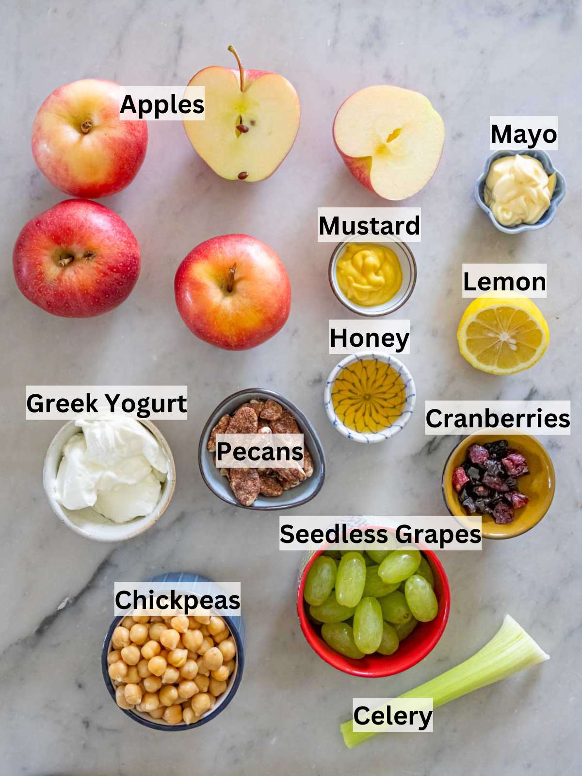 Ingredients for apple chickpea salad including apples grapes chickpeas celery and pecans.