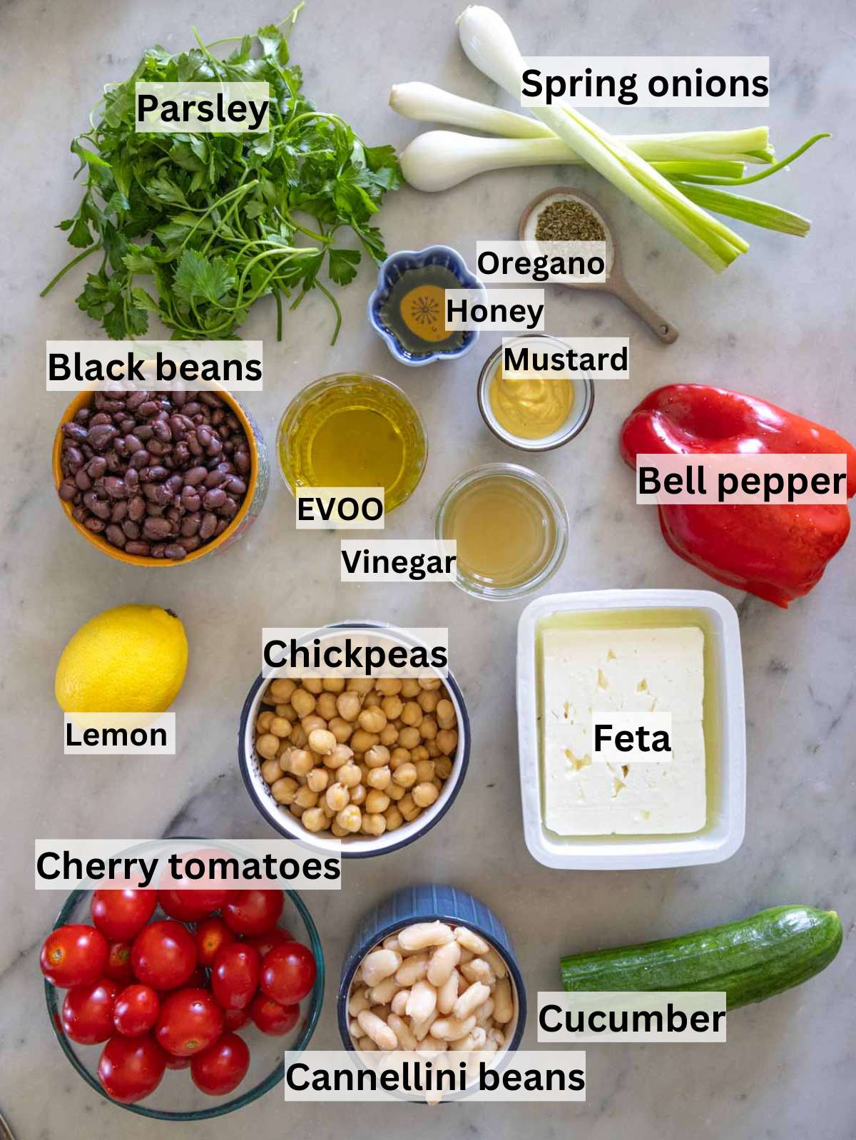 Ingredients for high protein bean salad arranged on a wooden kitchen table.