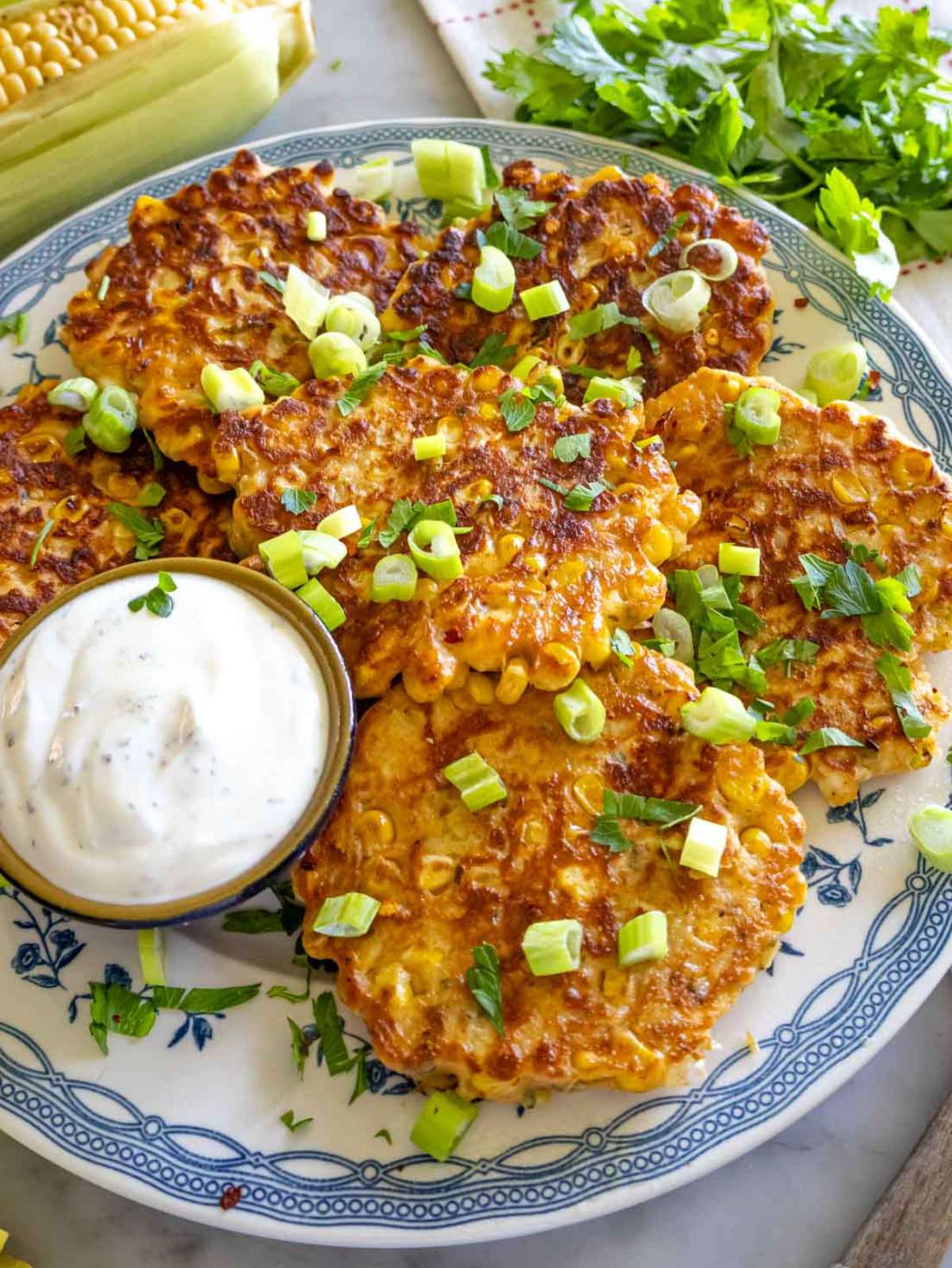 Mediterranean corn fritters served with yogurt dip and fresh herbs.