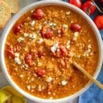 One pot tomato lentil soup finished with lemon zest olive oil and feta in a bowl.