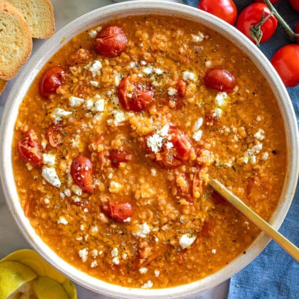 One pot tomato lentil soup finished with lemon zest olive oil and feta in a bowl.