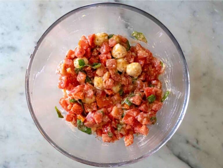 Step 1 Tomato mixture with basil garlic olive oil and cheese marinating in a white mixing bowl