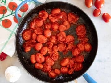 Step 2 Garlic herbs and seasoning cooking with tomatoes.