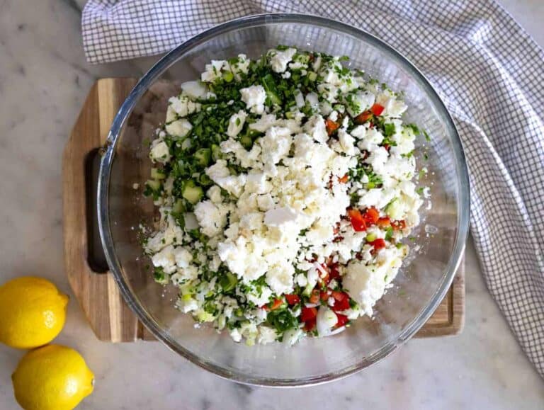 Step 3 Chopped vegetables and feta being added to high protein bean salad mixture.