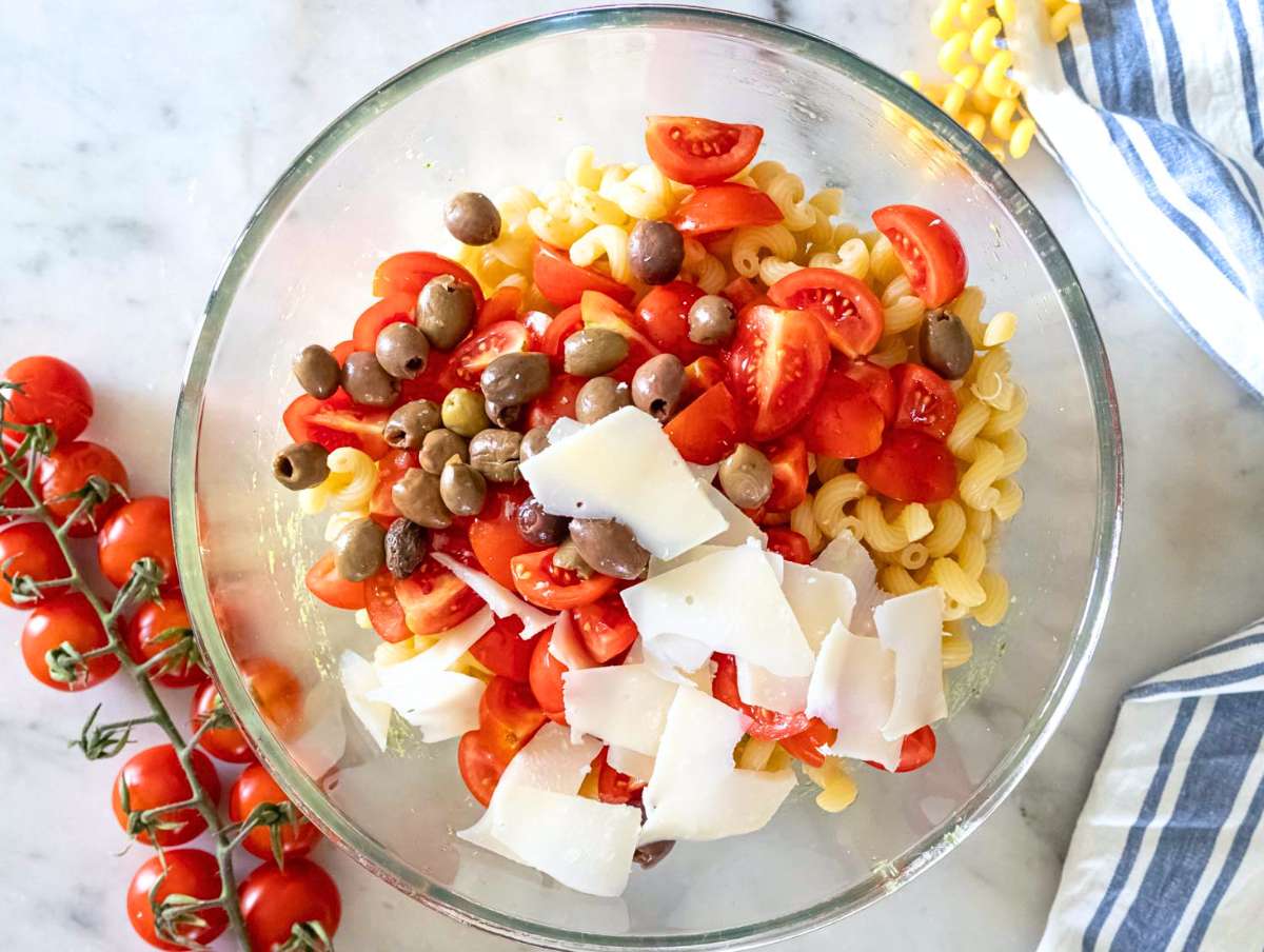 Step 3 Pasta cherry tomatoes parmesan and olives added to the bowl with the marinated beans.