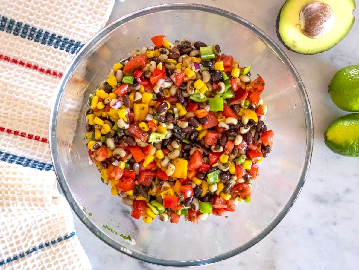 Step 3 Tossing Cowboy Caviar salad and adjusting flavors before chilling in the fridge.