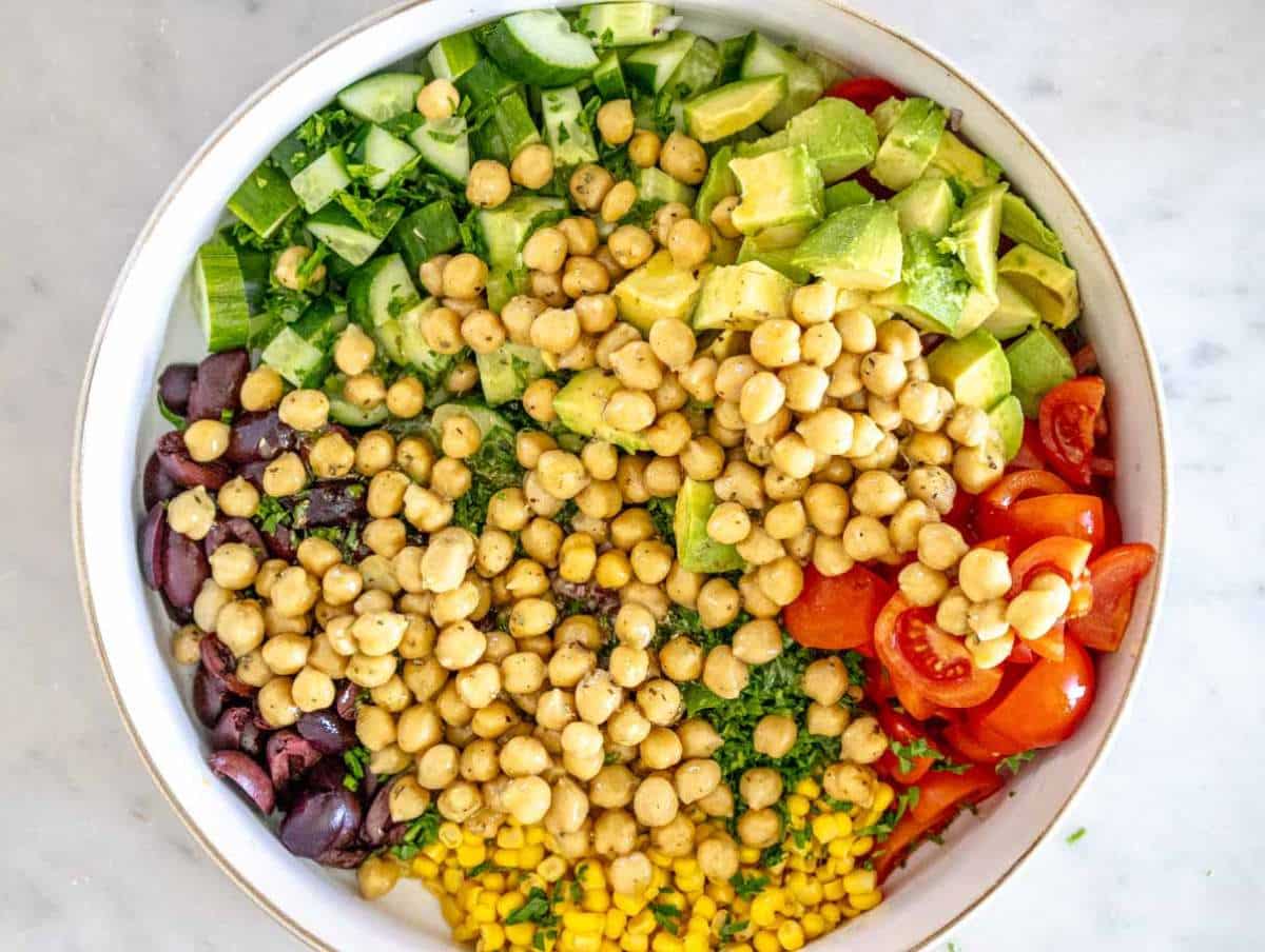 Step 3 Tossing chickpeas and dressing with vegetables for chickpea cucumber salad in large bowl.
