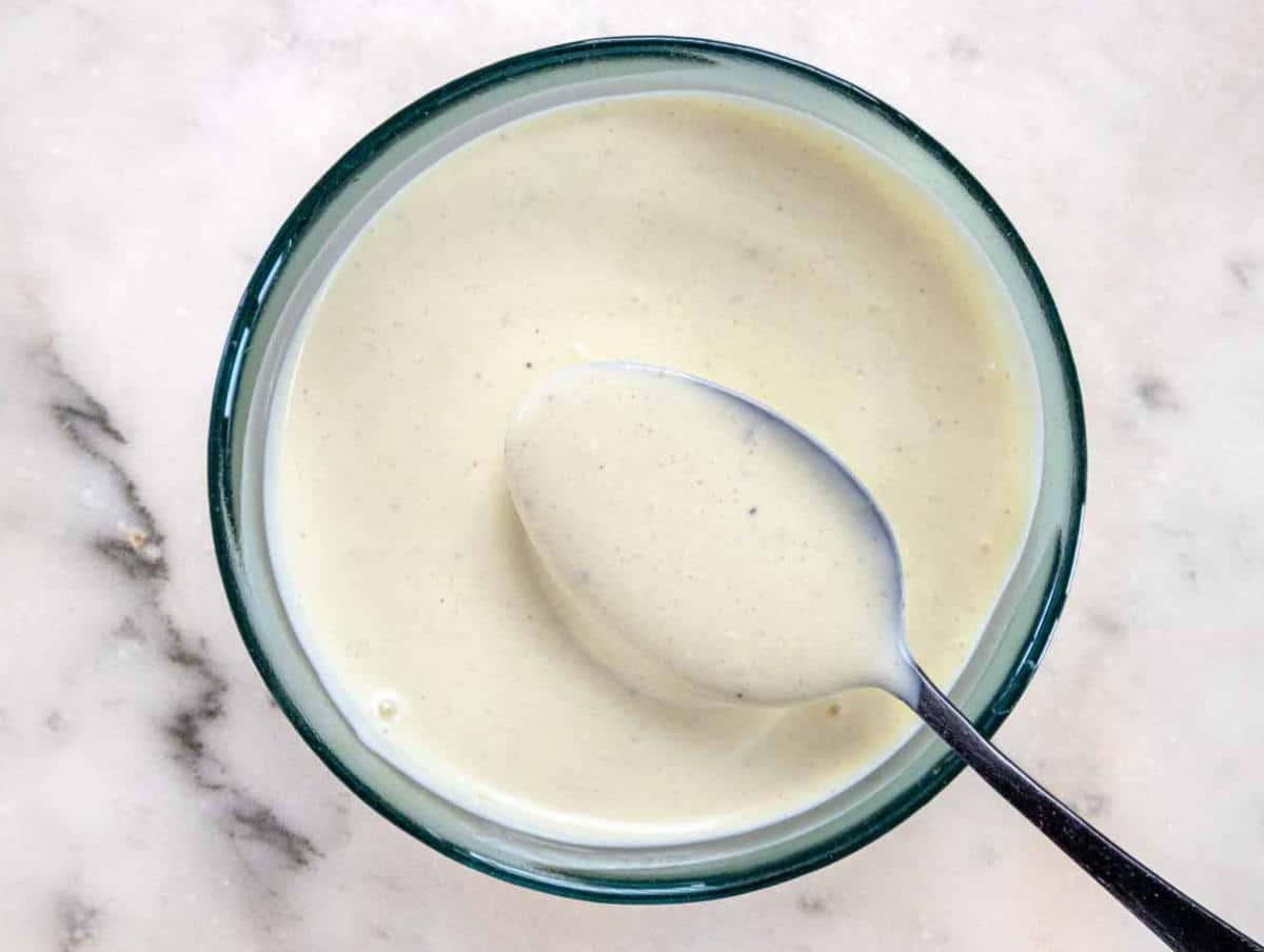 Step 3 Whisking creamy Greek yogurt dressing with mustard, vinegar, and mayo in a small bowl.