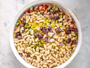 Step 3 mix pasta beans peppers cucumbers celery pickles dill corn and olives.