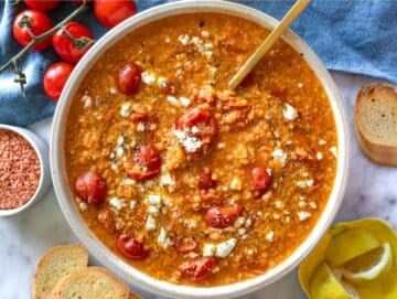 Step 4 A bowl of lentil tomato soup topped with lemon zest feta and olive oil.
