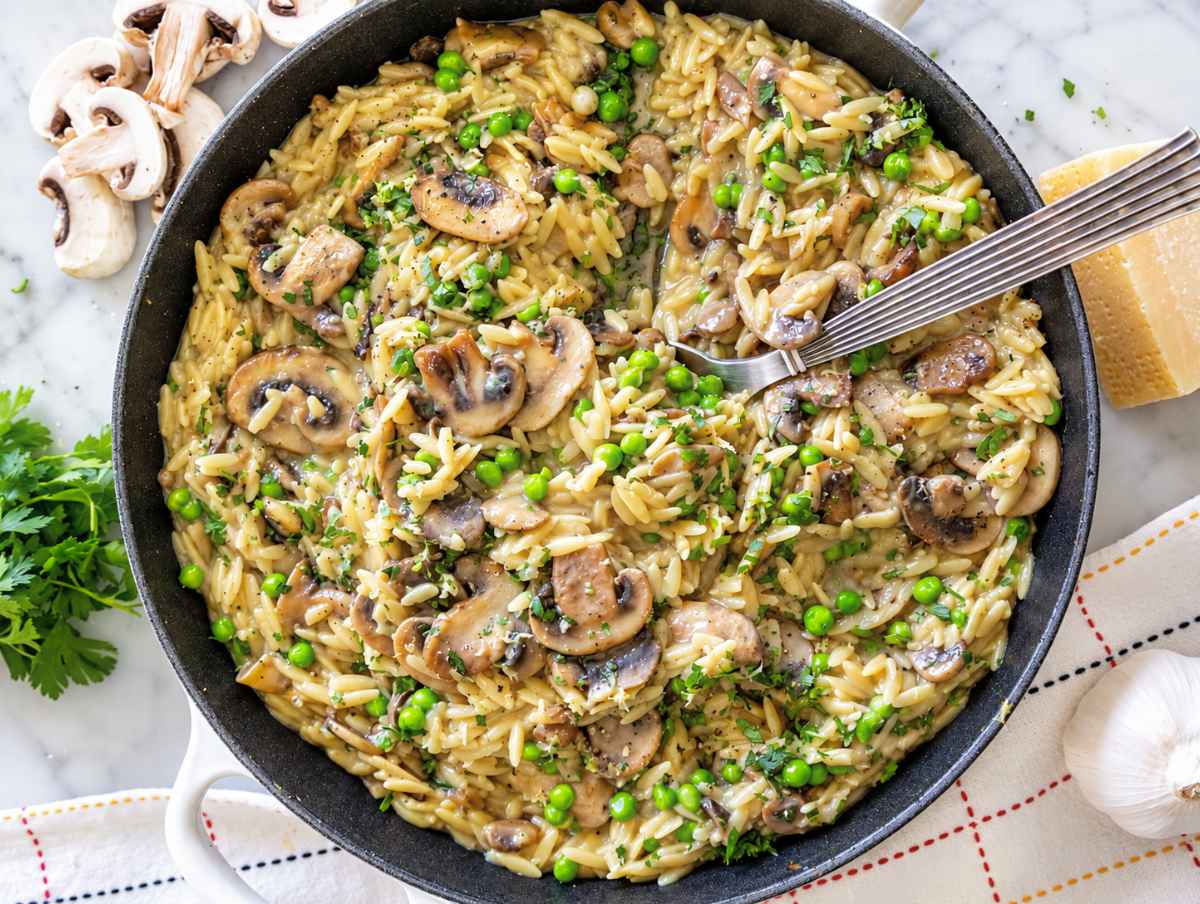 Step 4 Creamy mushroom orzo finished with peas, Parmesan, parsley, lemon zest, and black pepper.