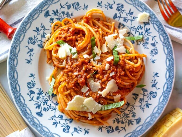 Step 4 Easy lentil bolognese served with pasta and topped with fresh parsley.